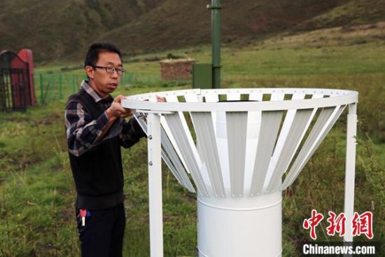 圖為班瑪縣氣象局工作人員在維護(hù)藏雪茶基地氣候站。青海省氣象局供圖