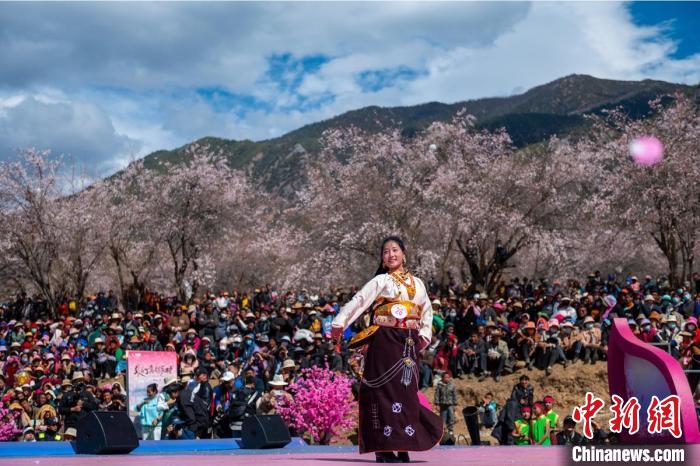 桃花林下精彩的“桃花仙子”選拔吸引村民或游客。　劉忠俊 攝