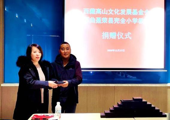 圖為西藏高山文化發(fā)展基金會(huì)理事長(zhǎng)溫麗向聶榮縣完全小學(xué)負(fù)責(zé)人捐助儀器?！∮谫e 攝
