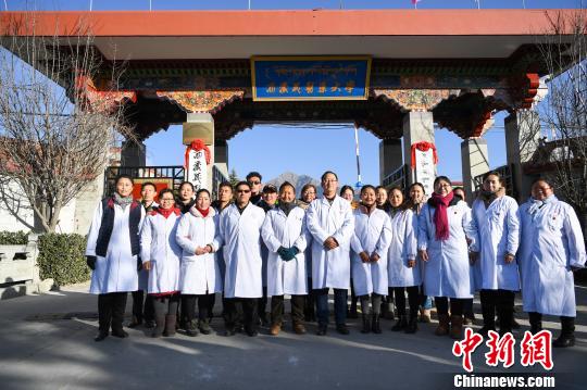 圖為該校師生在更名后的西藏藏醫(yī)藥大學校門前合影留念。　何蓬磊 攝