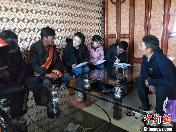 圖為調(diào)查組工作人員正在入戶調(diào)查?！∑钤鲚?攝