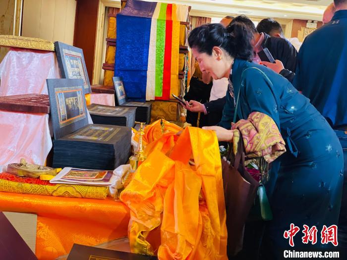 圖為現(xiàn)場(chǎng)藏族民眾向黃金書寫的大藏經(jīng)《甘珠爾》敬獻(xiàn)哈達(dá)?！O睿 攝