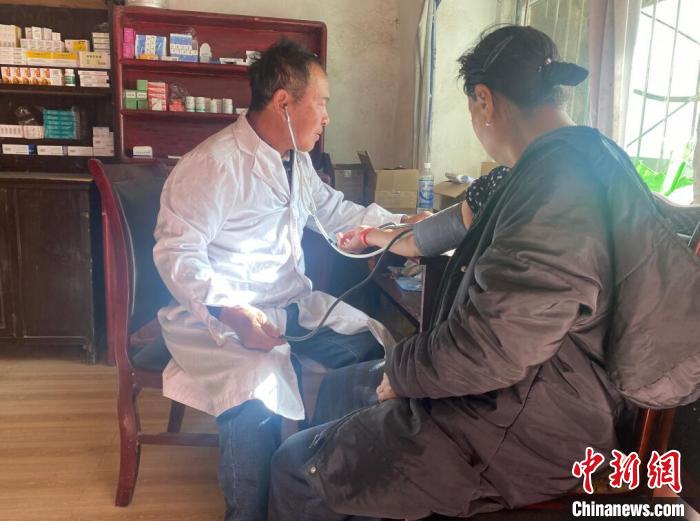 索木滾(左)為村民看病?！∪捞量h委宣傳部供圖