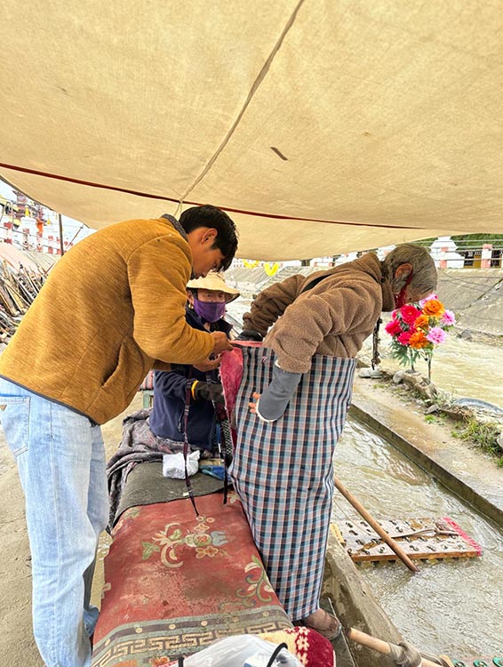 扎西奪爾登為路邊老人送去保暖圍腰。阿壩州文明辦供圖